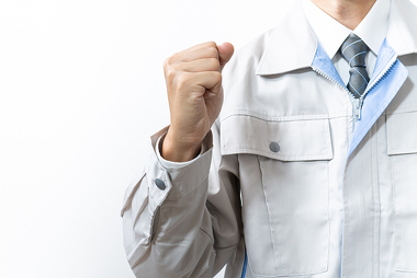 ガッツポーズをする作業服の男性